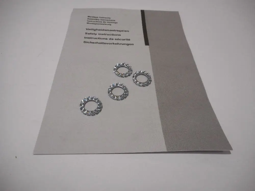 Bündel aus vier metallischen Zahnscheiben auf einer Anleitung. Die Anleitung enthält Sicherheitsinformationen von Remeha und Hinweise zur Montage.